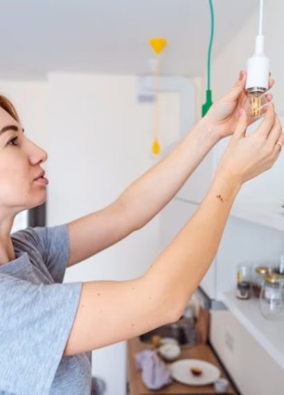 Une femme qui tient une ampoule électrique