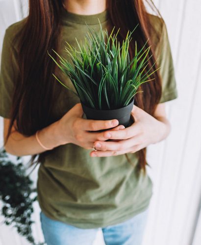 femme qui tient un pot de fleurs