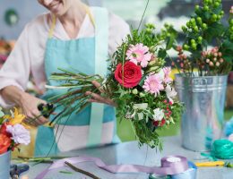 femme qui coupe les tiges de fleurs
