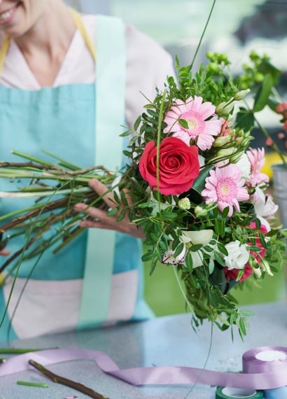 femme qui coupe les tiges de fleurs