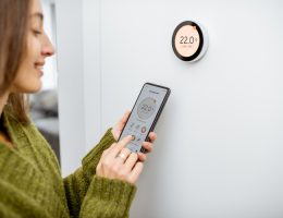 femme qui règle son thermostat