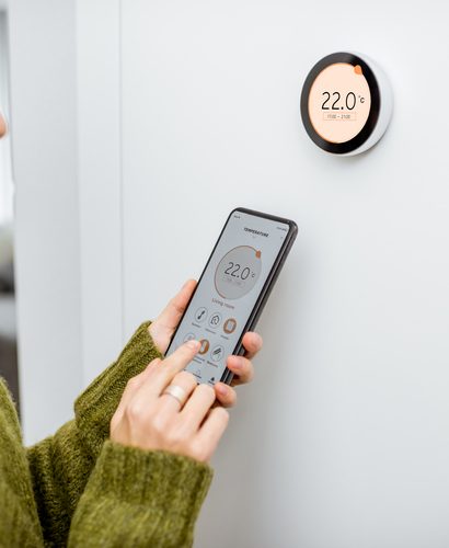 femme qui règle son thermostat