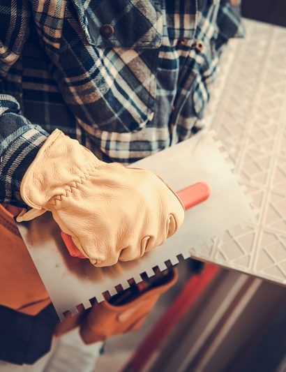 artisan qui pose du carrelage effet parquet