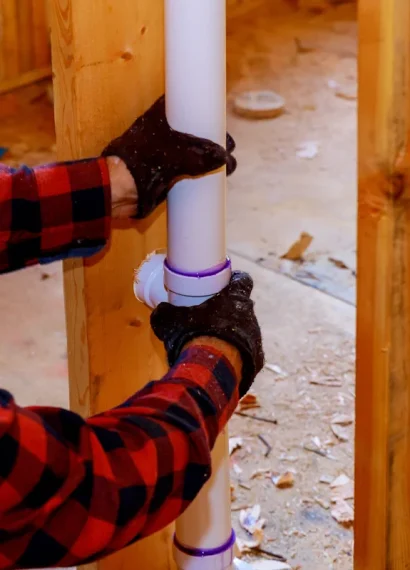 Un homme qui installe un tuyau en PVC