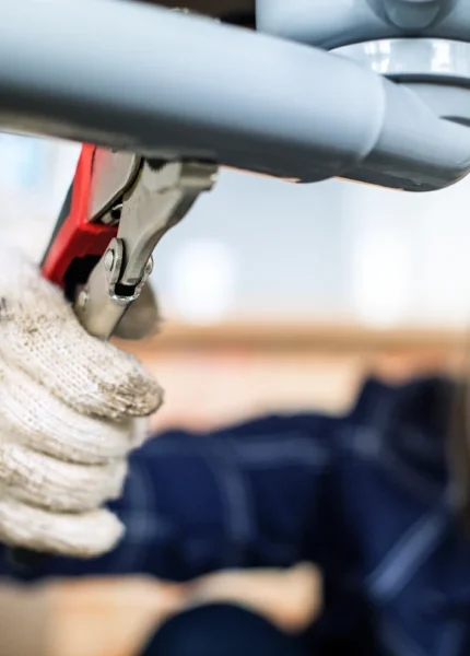 Une jeune femme qui utilise une pince sur un tuyau PVC
