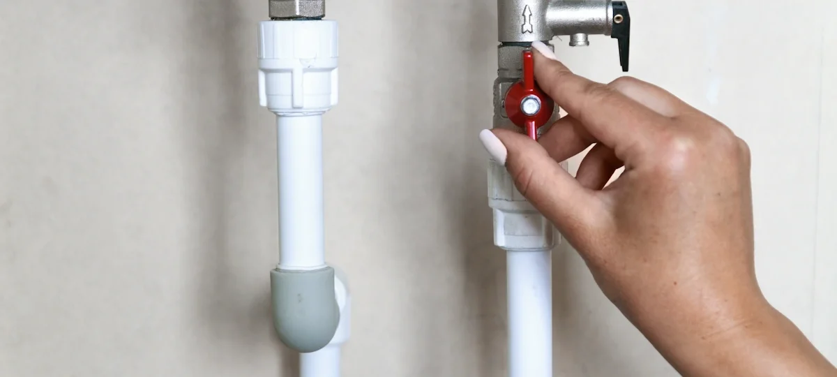 Une main qui actionne un robinet d'arrêt