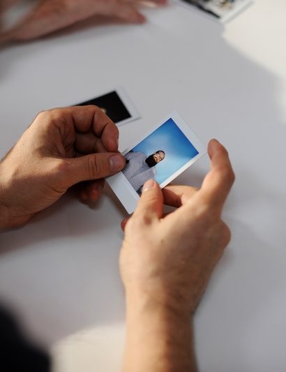 personne qui tient de photos dans la main