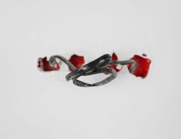 A close-up of a tangled wire protruding from red holes in a white background.