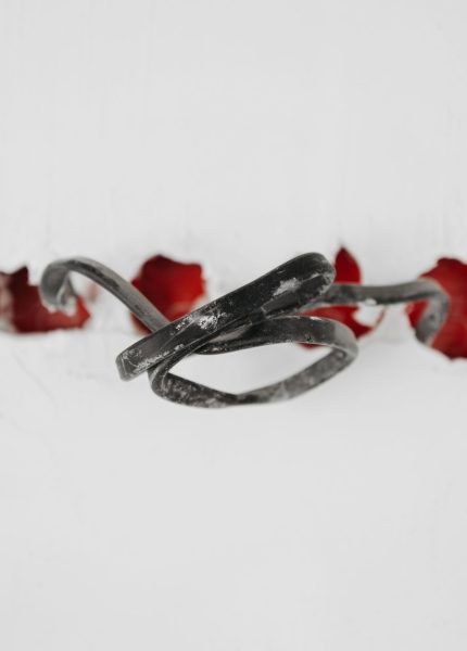 A close-up of a tangled wire protruding from red holes in a white background.