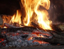 Close-up of a blazing fireplace with logs and glowing embers creating a warm atmosphere.