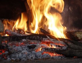Close-up of a blazing fireplace with logs and glowing embers creating a warm atmosphere.