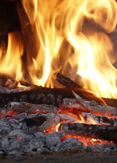 Close-up of a blazing fireplace with logs and glowing embers creating a warm atmosphere.