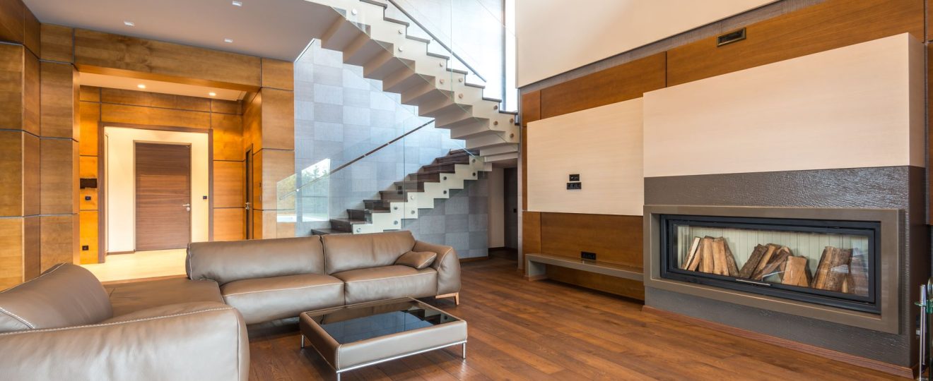 Spacious modern living room featuring a sleek fireplace and leather couches in a minimalist design.