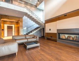 Spacious modern living room featuring a sleek fireplace and leather couches in a minimalist design.