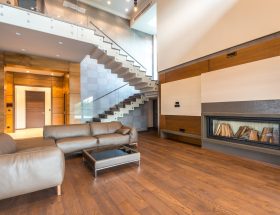 Spacious modern living room featuring a sleek fireplace and leather couches in a minimalist design.