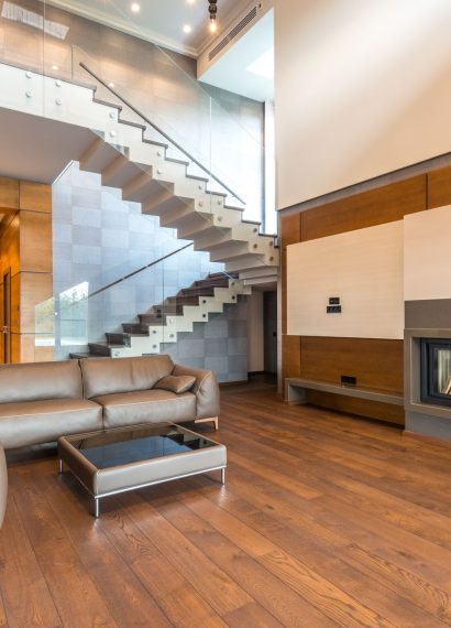 Spacious modern living room featuring a sleek fireplace and leather couches in a minimalist design.