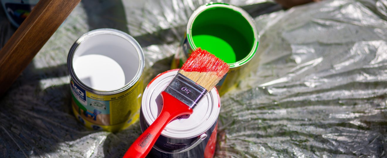 Colorful paint cans with brush on plastic