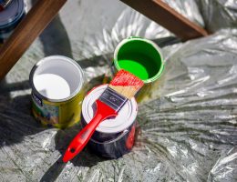 Colorful paint cans with brush on plastic