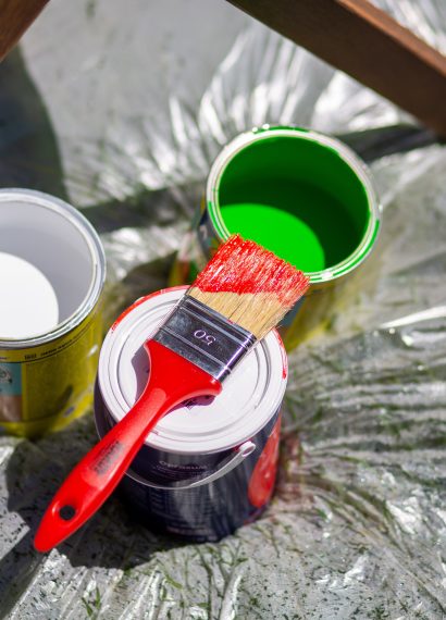 Colorful paint cans with brush on plastic