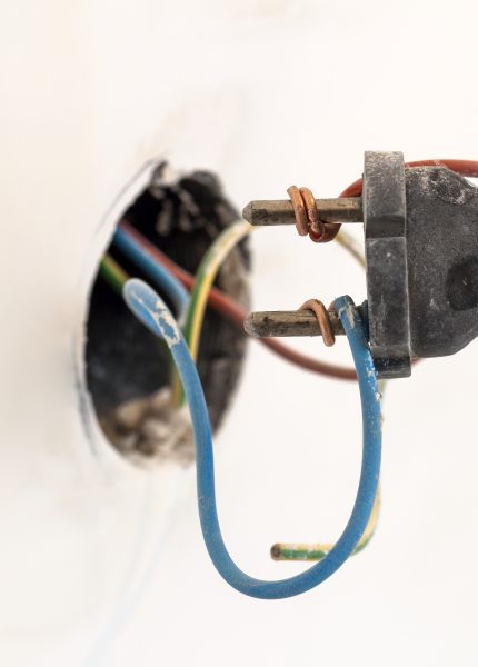 Exposed electrical wiring and plug close up