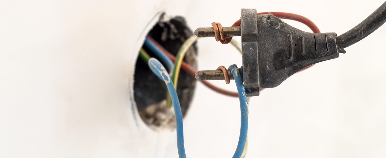 Exposed electrical wiring and plug close up