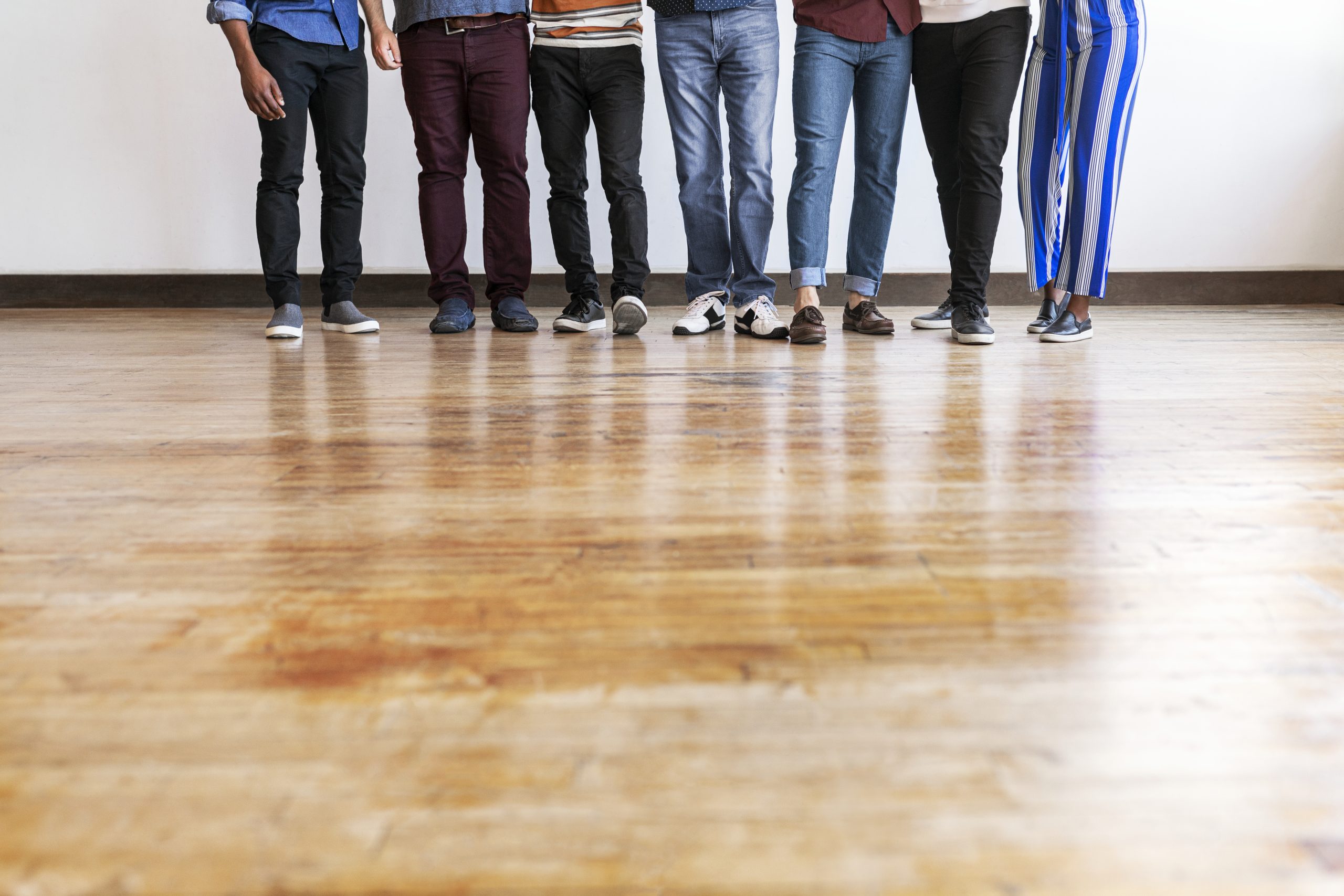 Group of people standing on wooden floor indoors