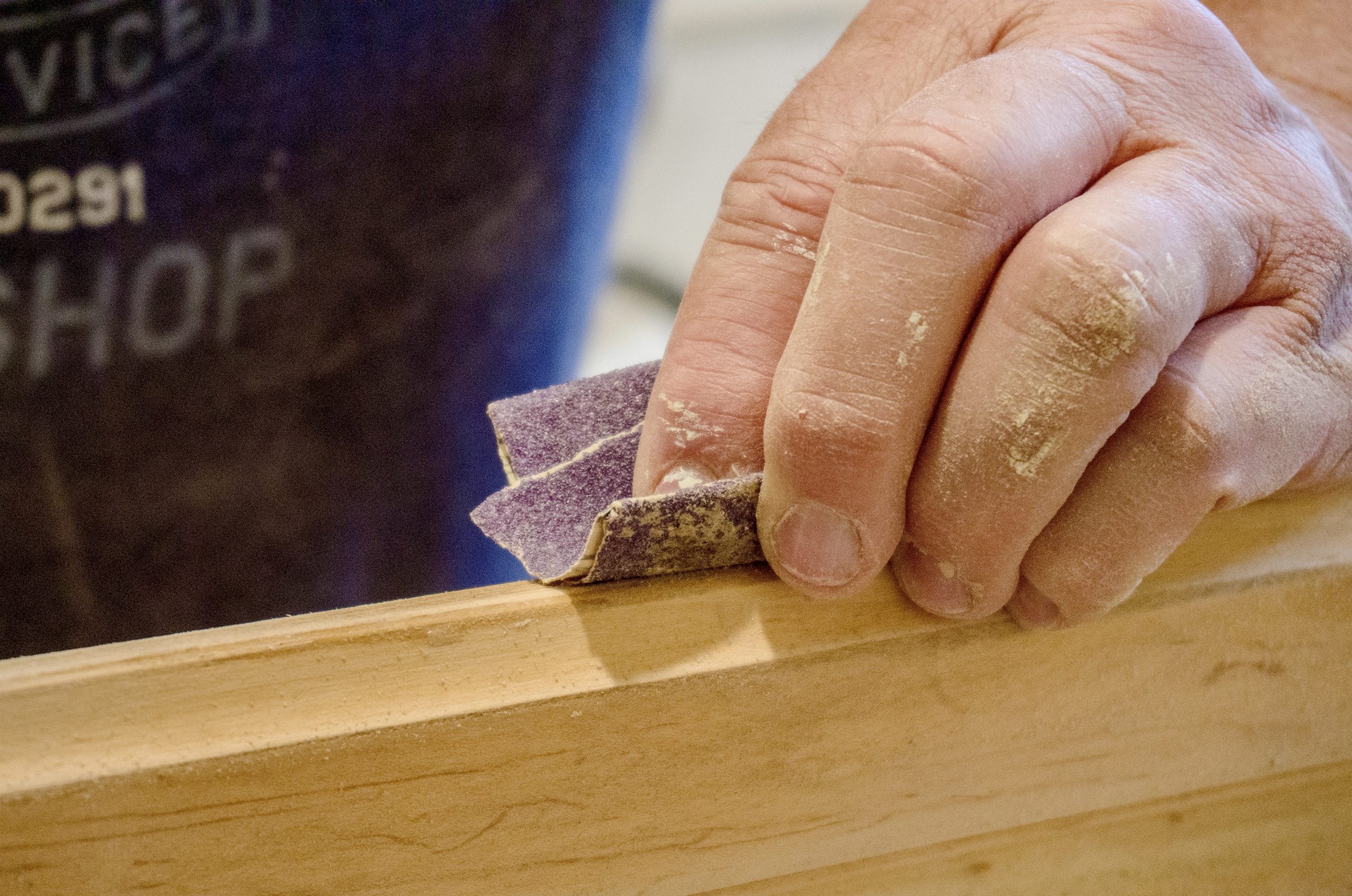 Hand sanding wood with abrasive paper