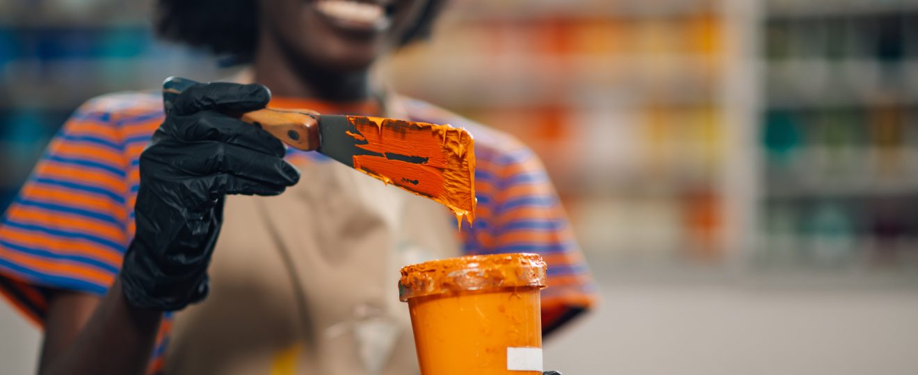 Interracial printing shop worker mixing paint for