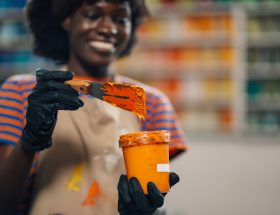 Interracial printing shop worker mixing paint for