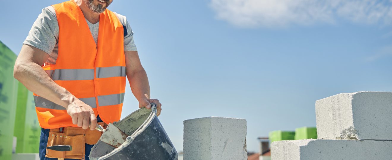 Man construction worker with blocks and bucket