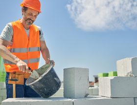 Man construction worker with blocks and bucket
