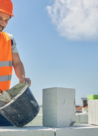 Man construction worker with blocks and bucket