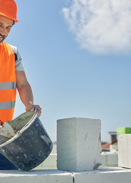 Man construction worker with blocks and bucket