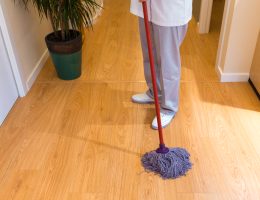 Person mopping the wooden floor indoors