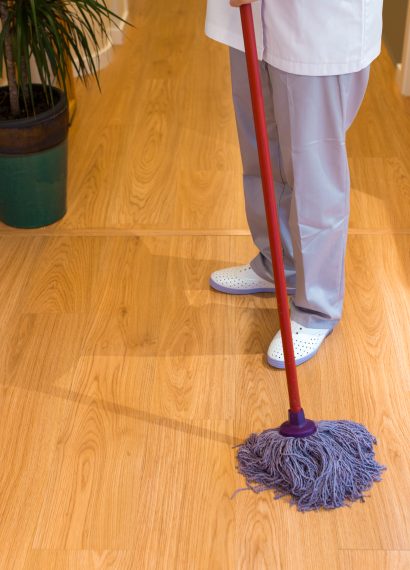Person mopping the wooden floor indoors