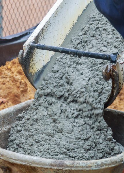 Pouring wet cement into a wheelbarrow