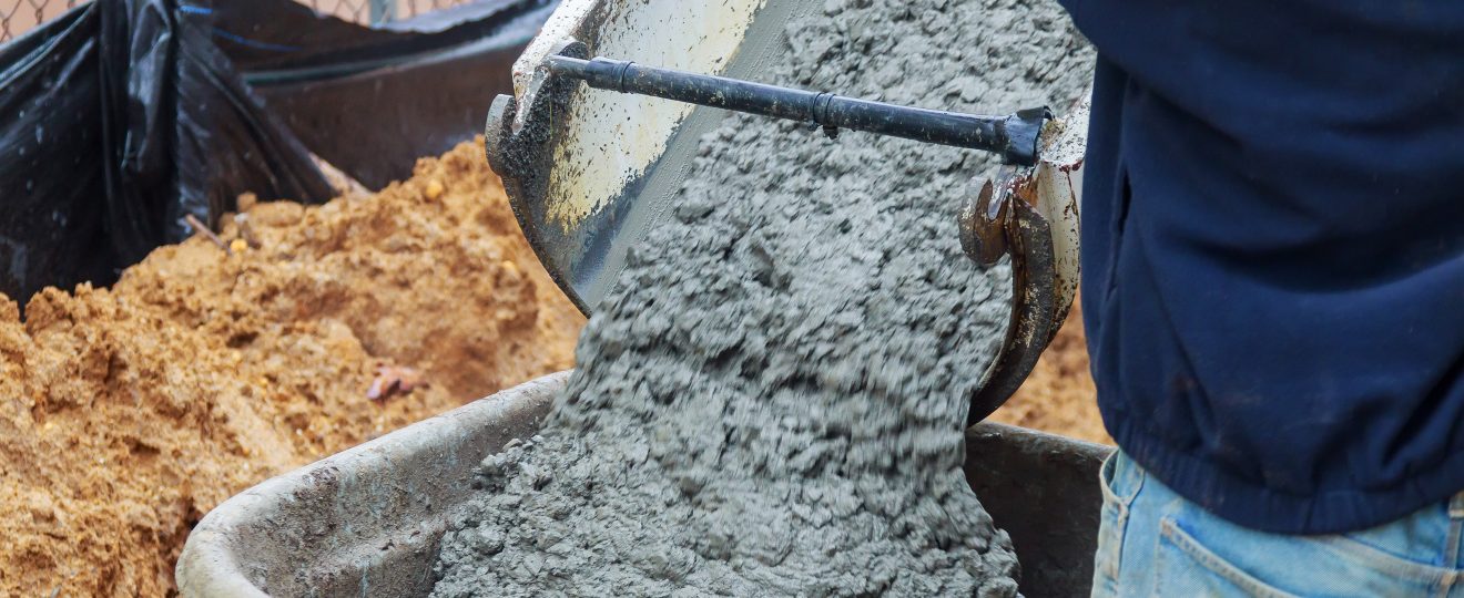 Pouring wet cement into a wheelbarrow