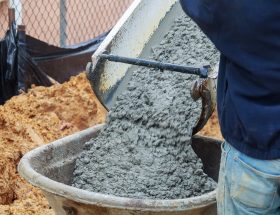 Pouring wet cement into a wheelbarrow